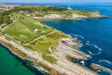 Santander, Cantabria 'daki Cabo Menor' da golf sahası, kuzey İspanya. Yarımadadaki çarpıcı golf sahalarının hava manzarası, kayalık kayalıklar ve Santander şehrinin manzaralı manzarası..