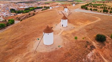 İspanya, Castilla-La Mancha 'daki Mota del Cuervo' nun tarihi yel değirmenlerinin hava manzarası. Akşam ışığında tepelerde Don Kişot 'un eski tarihi yel değirmenleri. Molinos de Viento de Mota del Cuervo