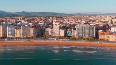 Gündoğumunda Gijon 'daki Playa de San Lorenzo plajının havadan görünüşü, Asturias, İspanya. Büyüleyici sahil, Cantabrian Denizi kıyısındaki sahil kasabasının manzaralı manzarasıyla sabah güneşiyle yıkandı.