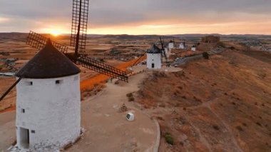 Günbatımında Consuegra 'nın tarihi yel değirmenlerinin havadan görünüşü, Castilla-La Mancha, İspanya. Akşam ışığında tepelerde Don Kişot 'un eski tarihi yel değirmenleri. Molinos de Viento de Consuegra