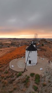 Günbatımında Consuegra 'nın tarihi yel değirmenlerinin havadan görünüşü, Castilla-La Mancha, İspanya. Akşam ışığında tepelerde Don Kişot 'un eski tarihi yel değirmenleri. Molinos de Viento de Consuegra