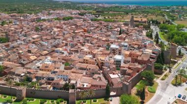 İspanya 'nın Balear Adaları' ndaki güneşli bir günde Mallorca 'nın güzel Alcudia kasabasının hava manzarası. St. Jaume Kilisesi ve Mayorka adasındaki diğer tarihi binalar.