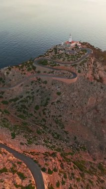 İspanya 'nın Balearic Adaları, Mallorca, Cape Formentor' daki pitoresk deniz fenerinin hava görüntüsü. Güzel, dolambaçlı bir yol, denizin üzerindeki yüksek bir uçuruma tünemiş deniz fenerine çıkar.