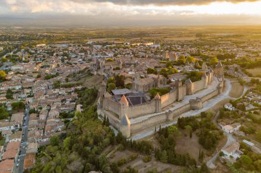 Ortaçağ şehri Carcassonne 'un havadan görünüşü ve güney Fransa' daki gündoğumunda bulunan kale. Güzel sabah aydınlığında ikonik ortaçağ kuleleriyle ünlü tarihi kale.