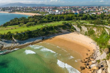 Playa de Matalenas plajının Santander, İspanya 'daki kayalık sahildeki Cape Mayor deniz feneri yakınlarındaki hava manzarası. Kuzey İspanya 'da yüksek kayalıkları ve kumlu plajı olan Santander' in güzel yeşil kıyıları..