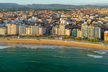 Gündoğumunda Gijon 'daki Playa de San Lorenzo plajının havadan görünüşü, Asturias, İspanya. Büyüleyici sahil, Cantabrian Denizi kıyısındaki sahil kasabasının manzaralı manzarasıyla sabah güneşiyle yıkandı.