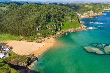 Gijon, Asturias yakınlarındaki inanılmaz Playa de La Nora plajı, kuzey İspanya. Asturias 'ın Cantabrian Denizi kıyısı boyunca turkuaz deniz suyuyla cennet gibi beyaz kumsal manzarası..