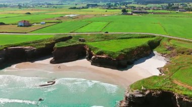 İspanya 'nın Galiçya kentindeki Cantabrian Denizi kıyısının hava manzarası. Yeşil çayırlar, yüksek uçurumlar, beyaz kumsallar ve turkuaz sular. Atlantik kıyısında manzaralı bir kıyı yolu var..
