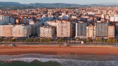 Gündoğumunda Gijon 'daki Playa de San Lorenzo plajının havadan görünüşü, Asturias, İspanya. Büyüleyici sahil, Cantabrian Denizi kıyısındaki sahil kasabasının manzaralı manzarasıyla sabah güneşiyle yıkandı.