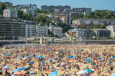 Donostia, İspanya - 22 Ağustos 2024: San Sebastian veya Donostia şehrinde turkuaz suları olan La Concha Sahili, İspanya, Bask Bölgesi, yaz boyunca. Kuzey İspanya 'da güzel bir yaz tatili.