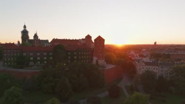 Polonya 'nın eski tarihi Krakow şehrindeki muhteşem Wawel Kalesi' nin üzerinde güzel bir gün doğumu. Wawel Hill 'deki kraliyet konutunun havadan görünüşü, sabah ışığında parlıyor.