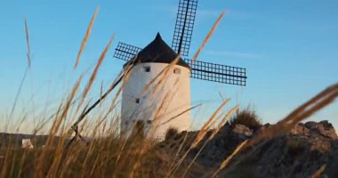 Günbatımında Consuegra 'nın tarihi yel değirmenlerinin görüntüsü, Castilla-La Mancha, İspanya. Akşam ışığında tepelerde Don Kişot karakterinin eski yel değirmenleri. Molinos de Viento de Consuegra