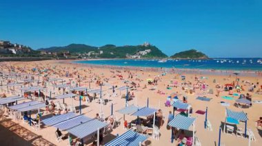 Donostia, İspanya - 22 Ağustos 2024: San Sebastian veya Donostia şehrinde turkuaz suları olan La Concha Sahili, İspanya, Bask Bölgesi, yaz boyunca. Kuzey İspanya 'da güzel bir yaz tatili.