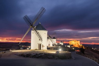 Consuegra 'nın tarihi yel değirmenleri alacakaranlıkta, Castilla-La Mancha, İspanya. Akşam ışığında tepelerde Don Kişot 'un eski tarihi yel değirmenleri. Molinos de Viento de Consuegra