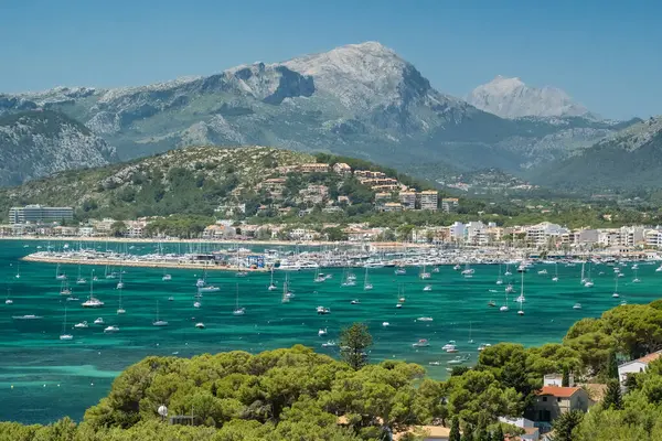 Port de Pollenca, İspanya - Mallorca, Balearic Adaları 'ndaki güzel panorama. Yazın demir atmış yelkenli tekneli turkuaz deniz koyunda. Manzara sahili, turizm, Akdeniz doğası, seyahat.
