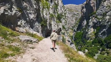 Ruta del Cares 'ı gezdiren, yazın Picos de Europa Ulusal Parkı' nda Cares Trail 'e giden Kastilya, Leon ve Asturias, İspanya arasındaki Cantabrian Dağları' nda bir biyosfer.