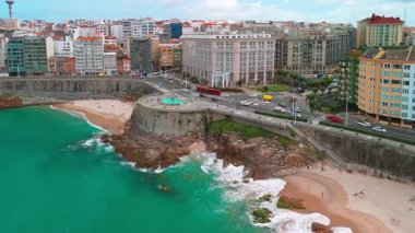 A Coruna, Galiçya, İspanya 'da güneşli bir günde Playa del Orzan plajının hava manzarası. Şehir merkezinde canlı turkuaz deniz suyuyla dolu uzun kumlu bir sahil. Kuzey İspanya 'da halk seyahati