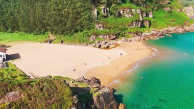 Gijon, Asturias yakınlarındaki inanılmaz Playa de La Nora plajı, kuzey İspanya. Asturias 'ın Cantabrian Denizi kıyısı boyunca turkuaz deniz suyuyla cennet gibi beyaz kumsal manzarası..