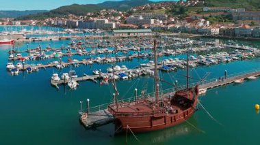 Baiona Limanı, Pontevedra, Galiçya, İspanya 'ya demirlemiş tarihi bir yelkenli gemisinin hava görüntüsü. Vigo Körfezi 'nde manzaralı bir kıyı mimarisi ve liman manzaralı bir ortaçağ merkezi bulunmaktadır..