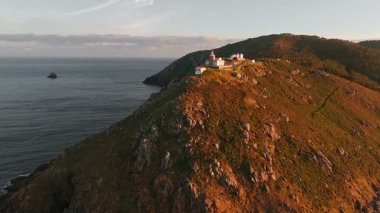 Güneş doğarken Cape Finisterre 'deki Faro de Fisterra deniz fenerinin havadan görünüşü, Costa de la Muerte, Galiçya, kuzey İspanya. Camino de Santiago hac yolunun son durağı.