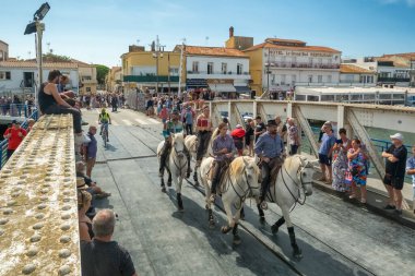 Le Grau-du-Roi, Fransa - 11 Eylül 2024: Course Camarguaise, Fransa 'nın güneyindeki Camargue bölgesinde düzenlenen geleneksel bir boğa güreşi etkinliği. At sırtındaki muhafızlar bir boğaya arenaya kadar eşlik etsin.
