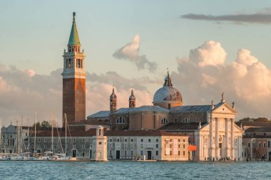 İtalya, Venedik 'te gün batımında San Giorgio Maggiore kilisesinin güzel manzarası. Kuzey İtalya 'daki San Giorgio Maggiore adasında 16. yüzyıldan kalma bir Benedikt kilisesi. Tarihi eser, dingin manzara.