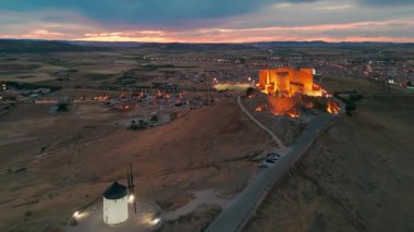 Consuegra 'nın tarihi yel değirmenlerinin geceleri havadan görünüşü, Castilla-La Mancha, İspanya. Alacakaranlıktaki tepelerde Don Kişot karakterinin eski tarihi yel değirmenleri. Molinos de Viento de Consuegra