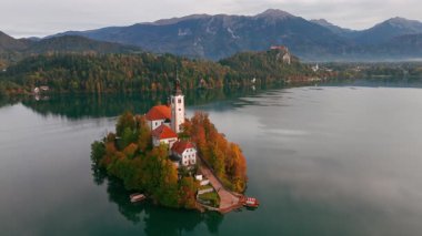Görkemli Göl 'ün hava manzarası Slovenya' nın sonbaharda gündoğumunda kanadı. Adadaki hac kilisesine yakın çekim, uçurumdaki Kanlı Kale ve güzel gölün üzerinde yüzen sıcak hava balonu..