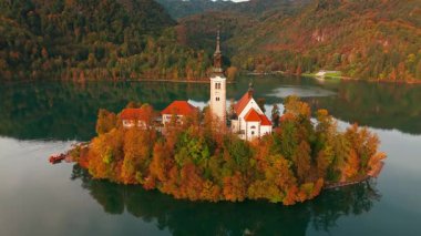 Görkemli Göl 'ün hava manzarası Slovenya' nın sonbaharda gündoğumunda kanadı. Adadaki hac kilisesine yakın çekim, uçurumdaki Kanlı Kale ve güzel gölün üzerinde yüzen sıcak hava balonu..