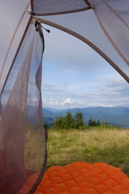 Çadırdan dağ manzarası görünüyor. Seyahat, dağ yürüyüşü, ormanda dinlenme..