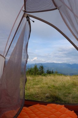Çadırdan dağ manzarası görünüyor. Seyahat, dağ yürüyüşü, ormanda dinlenme..