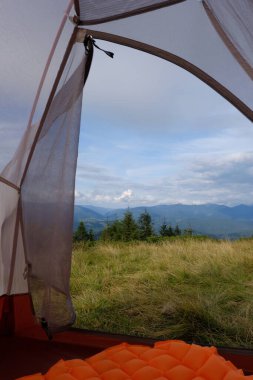 Çadırdan dağ manzarası görünüyor. Seyahat, dağ yürüyüşü, ormanda dinlenme..