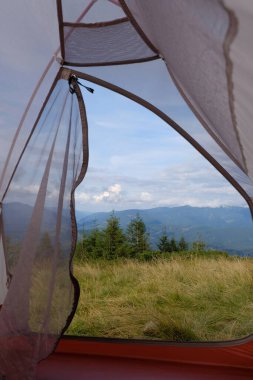 Çadırdan dağ manzarası görünüyor. Seyahat, dağ yürüyüşü, ormanda dinlenme..