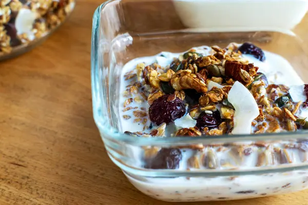 Sütlü granola ve beyaz kasede taze böğürtlen. Sağlıklı kahvaltı kavramı