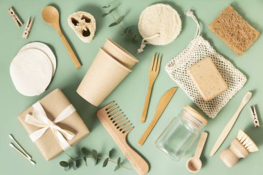 Yeniden kullanılabilir çevre dostu ürünler. Sıfır atık. Eko doğal kağıt bardaklar, bambu çatal bıçaklar, pastel yeşil arka planda doğal temizlik ürünleri, düz yatak. Plastiksiz sürdürülebilir yaşam tarzı