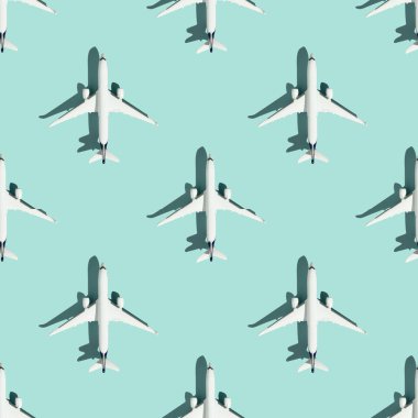 Creative composition made with white passenger plane on colorful background. Summer travel or vacation pattern. Flat lay, square composition