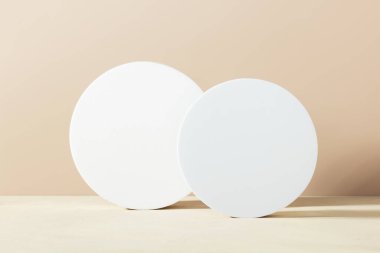 Beyaz köpük dairesi, bej masa üzerinde şekil kaidesi fotokopi alanı, yan görüş. Ürünler için podyum modelleme geçmişi. Reklam şablonu. Köpük platformu. Soyut geometrik kaide.