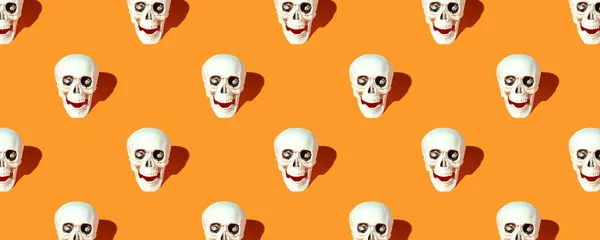 バナー ハロウィンデコレーション オレンジ色の背景を持つ人間の頭蓋骨パターン — ストック写真