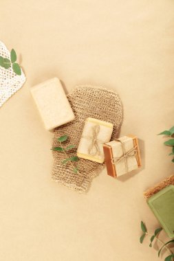 Çevre dostu yaşam tarzı konsepti. Doğal el yapımı sabun çubuğu ve bej arkaplanda havluyla üst manzara fotoğrafı.