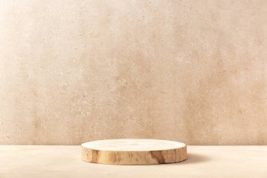 Ürün sunumu için boş yuvarlak ahşap podyum, bej arka planda pembe çigila çiçekleri. Silindir şeklindeki vitrinli kozmetik reklamlar için doğal malzemeler. Model konsepti.