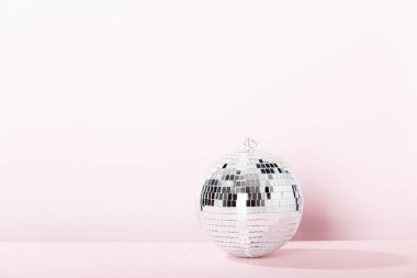 Pembe arka planda disko topu. Disko katı, parti, gece hayatı, dışarı çıkma konsepti..