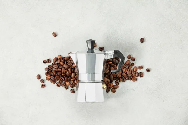 Flat lay of moka pot coffee maker and coffee beans on grey stone background