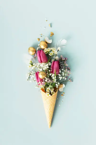부활절 아름다운 꽃들이 아이스크림 과푸른 배경에 황금빛 해오라기알 스톡 사진
