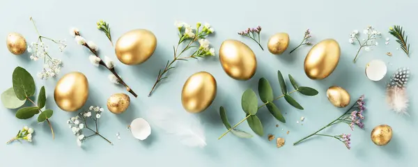 Osterkomposition Aus Goldenen Wachteleiern Federn Und Frühlingsblumen Vor Pastellblauem Hintergrund Stockbild