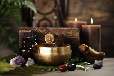 Altın bir şarkı kasesi, ahşap bir forvet, kristaller ve ruhsal ya da meditasyon amacıyla dizilmiş mumlar..