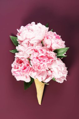 Pembe şakayıkların yaratıcı çiçek aranjmanı. Dondurma külahında şekillendirilmiş..