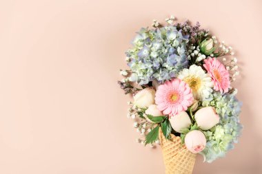 Yumuşak bir arka planda gül, ortanca ve papatya içeren yaratıcı çiçek düzenlemeleri..