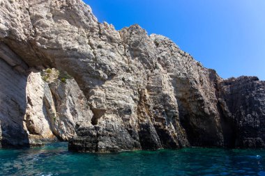 Berrak mavi suyu ve engebeli uçurumları olan doğal bir taş kemerin çarpıcı manzarası. Bu kıyı sahnesinde doğa ve seyahat meraklıları için mükemmel doğal güzellikler ve jeolojik oluşumlar sergileniyor..