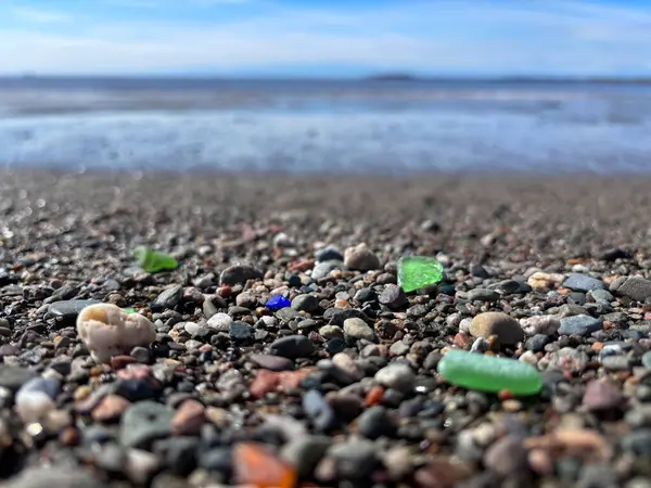 カナダのニューブランズウィック湾沿いのビーチの小石の間に異なる色の海ガラス ロイヤリティフリーのストック写真