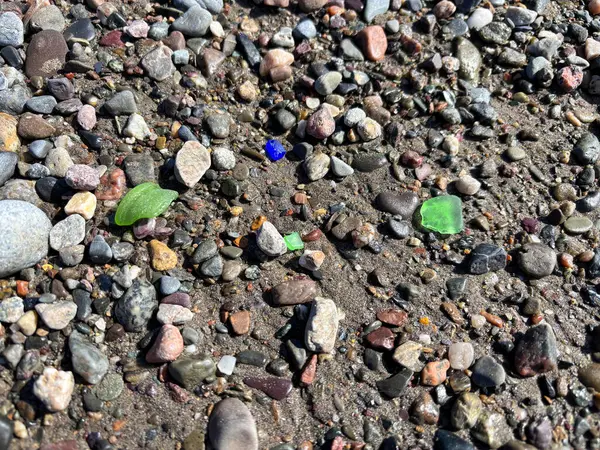 位于加拿大新不伦瑞克芬迪湾海滩上的卵石中的不同颜色的海玻璃 免版税图库图片